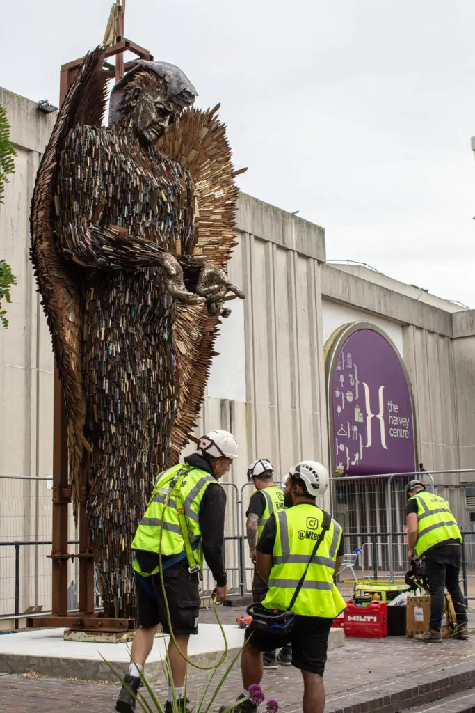 Workers installing sculpture