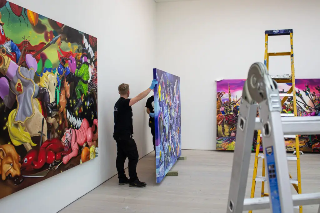 Workers installing canvas art