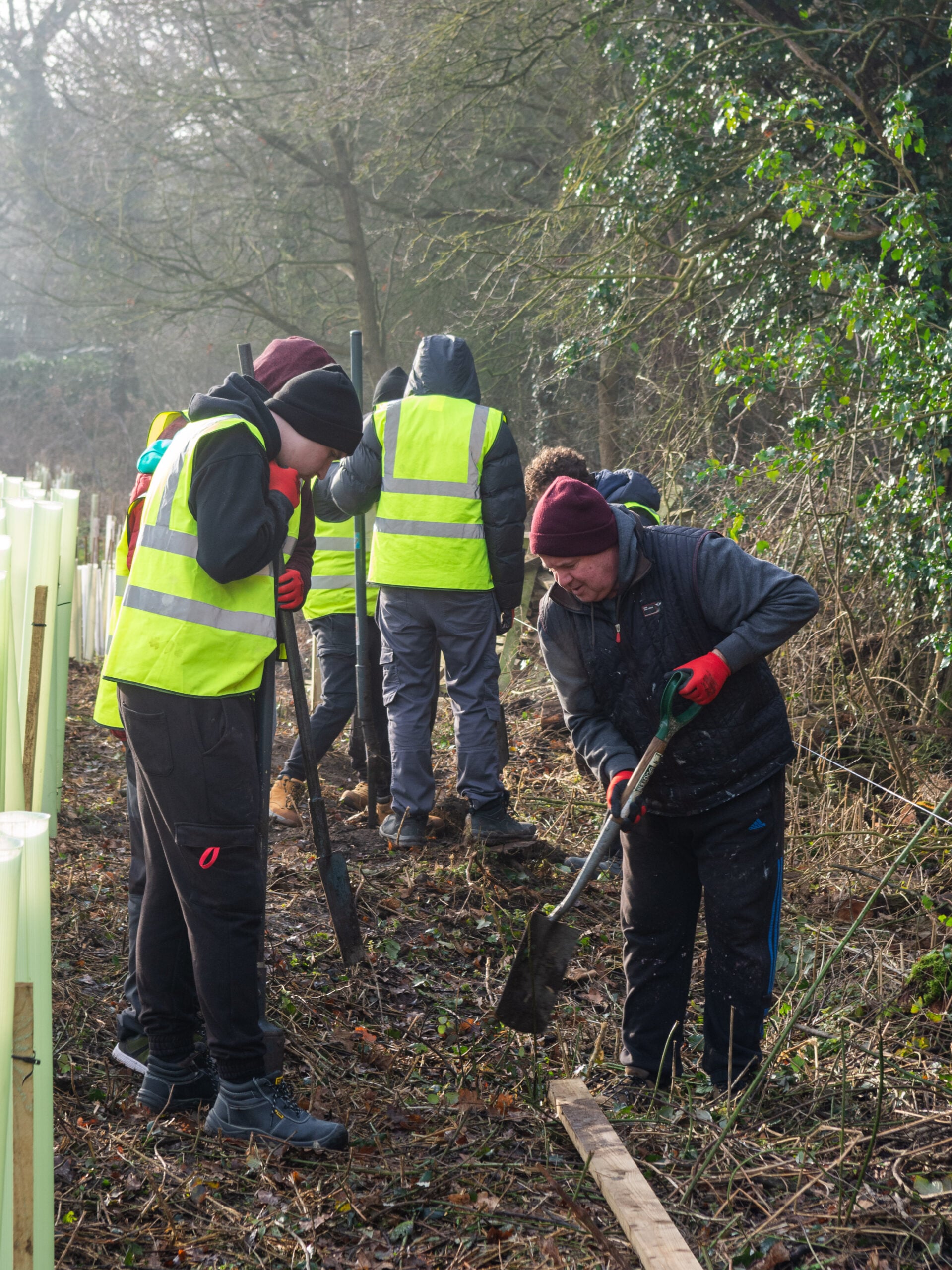 Construction students and staff preparing the ground for fence psots