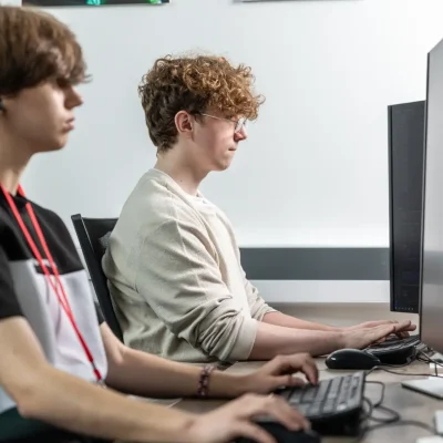 two male T Level students coding on computers